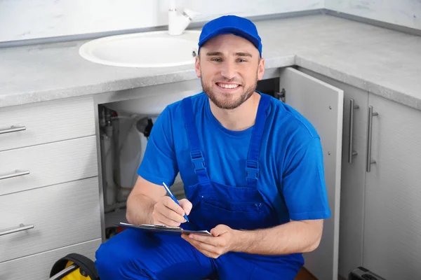 Professionele Loodgieter Uniform Met Klembord Buurt Van Aanrecht — Stockfoto