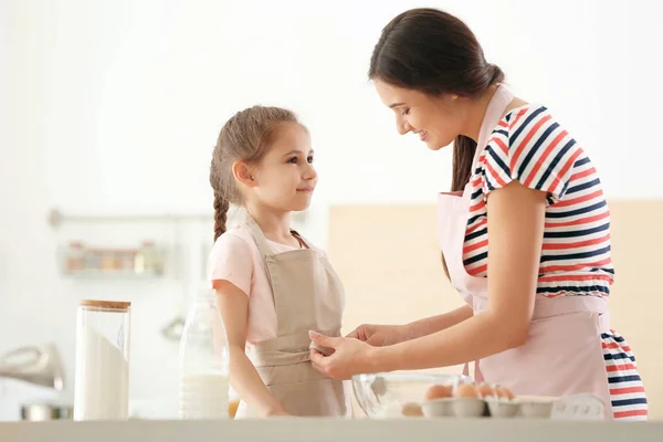 Young Woman Helping Her Daughter Put Apron Kitchen Making Dough — Stock Photo, Image