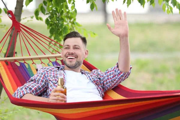 Stilig Ung Man Med Flaska Vilar Hängmatta Utomhus — Stockfoto