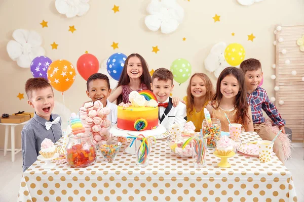 屋内のテーブルで誕生日を祝ってかわいい子供たち — ストック写真