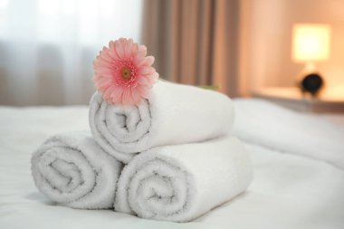 Otel odasındaki yatakta temiz havlular.