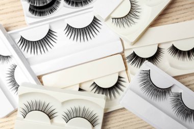 Farklı türde paketlerine ahşap arka plan üzerinde yanlış eyelashes
