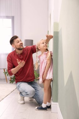 Genç adam kızının yükseklik evde ölçme