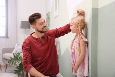 Genç adam kızının yükseklik evde ölçme