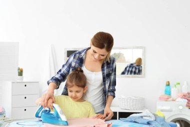 Çamaşır odasında kızı Ütü giysileri ile ev hanımı