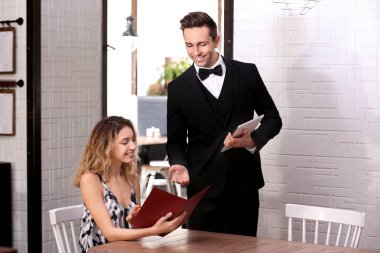 Genç garson istemci restoranda sipariş alarak