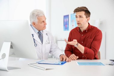 Man with health problems visiting urologist at hospital clipart