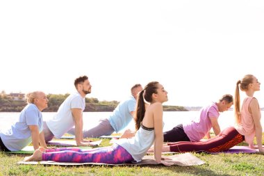 Pratik yoga Nehri yakınında güneşli günde gurup