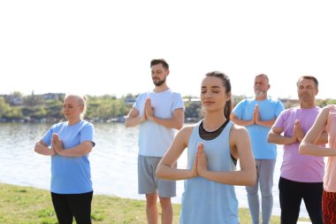 Pratik yoga Nehri yakınında güneşli günde gurup