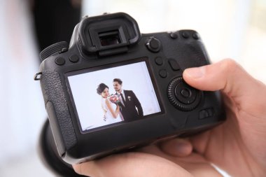 Profesyonel fotoğrafçı bir görüntüde, closeup fotoğraf makinesi ile güzel düğün çifti holding