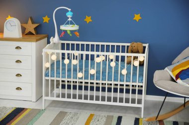 Bebek odasının içinde rahat bir beşik ve sallanan sandalye var.