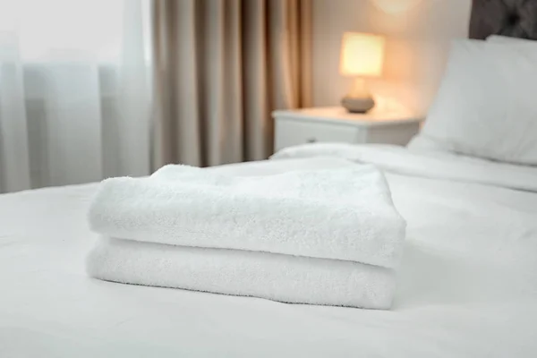 stock image Stack of towels on bed in modern hotel room