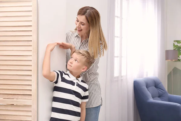 Mujer Joven Midiendo Altura Hijo Casa — Foto de Stock