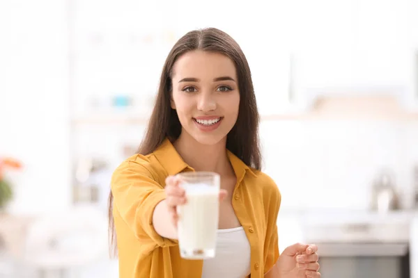 年轻漂亮的女人在家里喝牛奶 — 图库照片