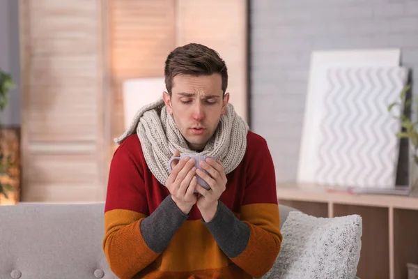 Jovem Doente Com Xícara Bebida Quente Sofrendo Frio Sofá Casa — Fotografia de Stock