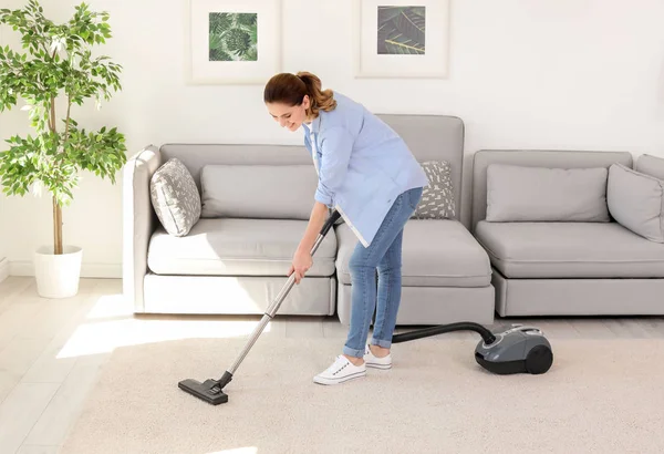 自宅の掃除機でのカーペットから汚れを除去する女性 — ストック写真