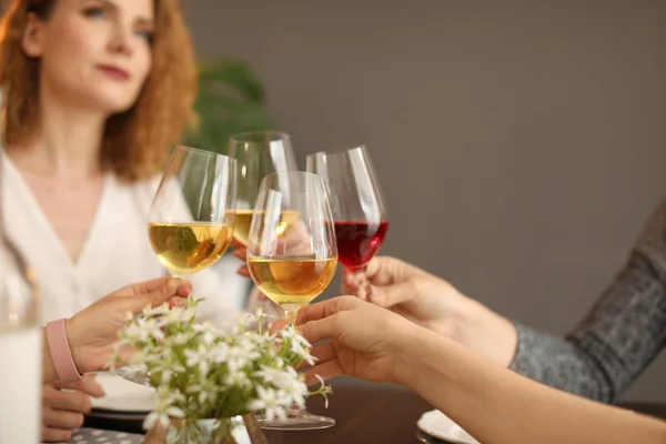 Young people with glasses of delicious wine at table