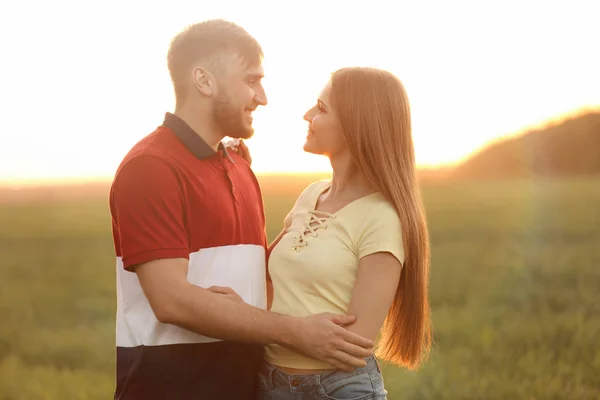 Happy young couple in green field on sunny spring day