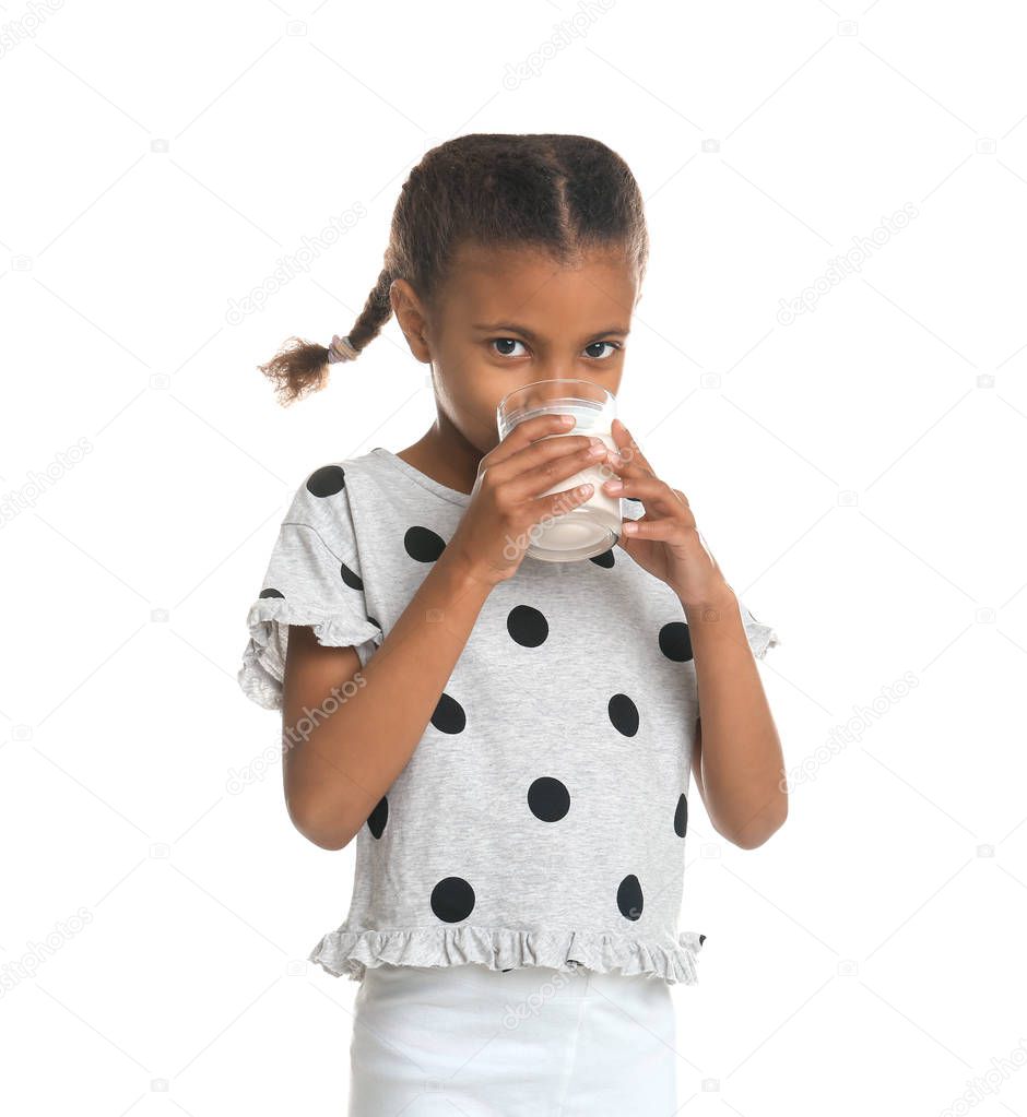 Adorable African-American girl with glass of milk on white background
