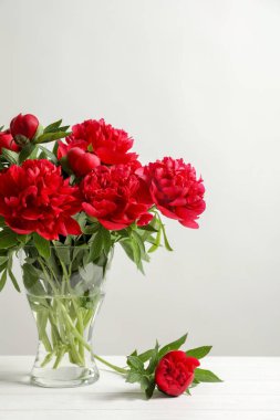 Açık renkli karşı masada güzel çiçek açan peonies vazo