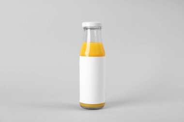 Işık arka plan üzerinde lezzetli taze meyve suyu şişesiyle