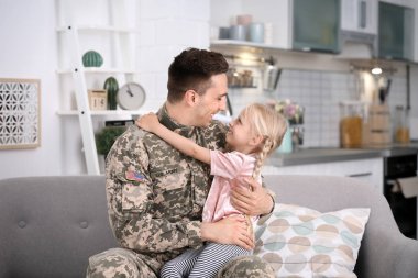 Küçük kızı evde kanepe ile askeri üniformalı genç adam