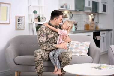 Küçük kızı evde kanepe ile askeri üniformalı genç adam