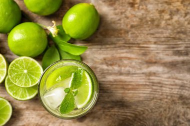 Ferahlatıcı limon içecek ve malzemelerin üzerine ahşap arka plan, üstten görünüm