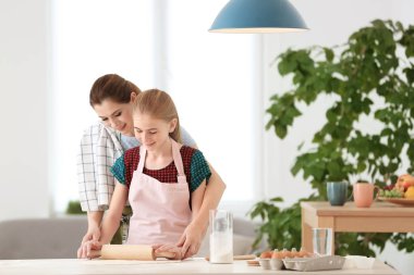 Anne ve kızı mutfakta masada hamur yapma