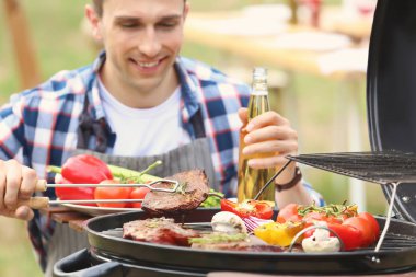 Pişirme et ve sebze Barbekü ızgara açık havada Genç adam