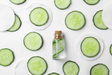 Beyaz zemin üzerine salatalık, şişe ve pamuk yastıkları ile düz yatıyordu kompozisyon