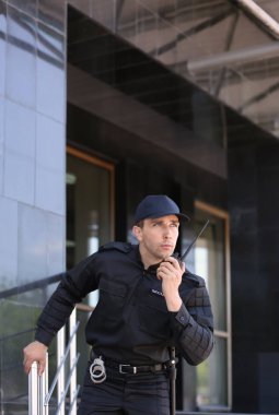 Erkek güvenlik görevlisi taşınabilir radyo vericisi açık havada kullanma