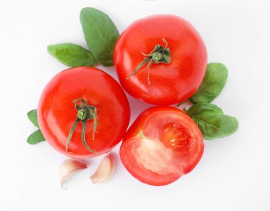 Olgun kırmızı domates, sarımsak ve beyaz arka planda, fesleğen görünümü top