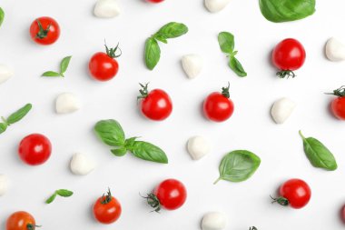 Domates, mozzarella peynirli cips ve fesleğen ışık arka plan üzerinde düz yatıyordu kompozisyon