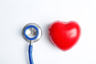 Açık renkli, üstten görünüm stetoskop ve kalp modeli. Tıbbi donatımı