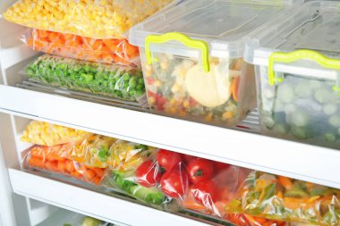 Konteyner ve buzdolabı derin dondurulmuş sebzeler ile plastik torbalar