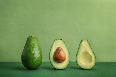 Composition with ripe avocados on color background clipart