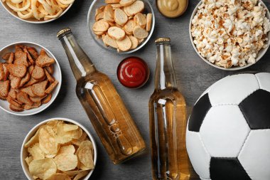 Tablo lezzetli aperatifler ve TV, üst görünümden futbol izlemek için hazırlanan bira dolu