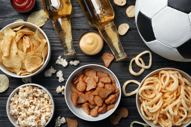 Tablo lezzetli aperatifler ve TV, üst görünümden futbol izlemek için hazırlanan bira dolu