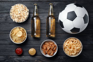 Tablo lezzetli aperatifler ve TV, üst görünümden futbol izlemek için hazırlanan bira dolu
