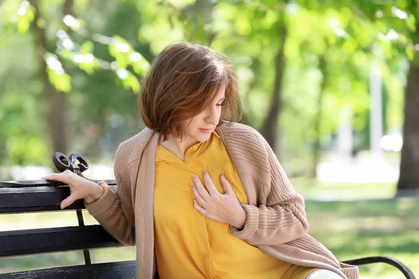 在公园长凳上心脏病发作的成熟妇女 — 图库照片