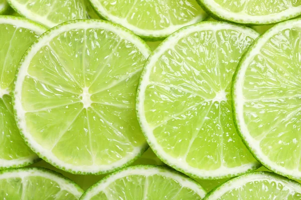 Fresh sliced ripe limes as background, top view