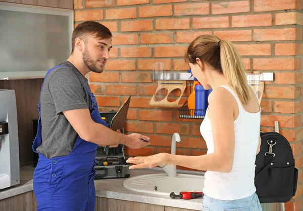 Professionele Loodgieter Met Client Buurt Van Aanrecht — Stockfoto