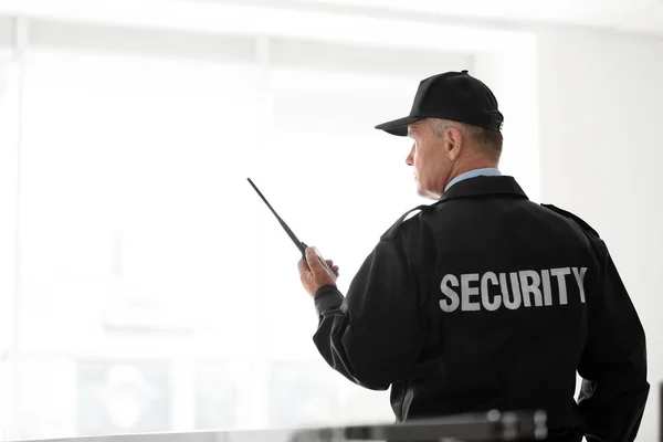 Male Security Guard Using Portable Radio Transmitter Light Background — Stock Photo, Image