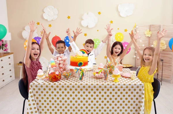 屋内のテーブルで誕生日を祝ってかわいい子供たち — ストック写真