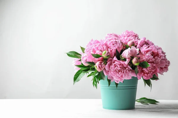Açık Renkli Karşı Masada Güzel Şakayık Çiçekleri Ile Kova — Stok fotoğraf