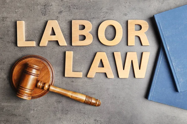 Flat lay composition with words LABOR LAW on grey background