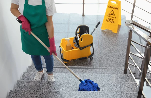 階段を掃除モップを持つ若い女性 — ストック写真