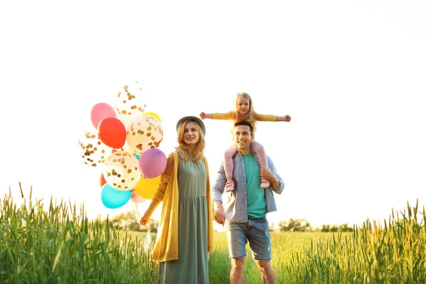 Happy family with colorful balloons outdoors on sunny day