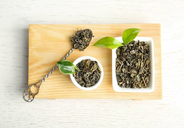 乾燥茶とテーブル上面の緑の葉の木製トレイ — ストック写真